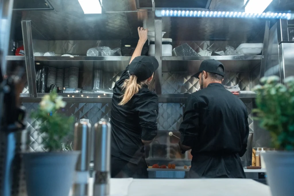 Kitchen staff working in a restaurant's commercial kitchen, where the layout affects how fast they work